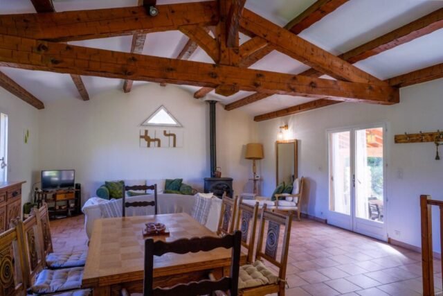 Salle à manger sous charpente provençale avec grande table en bois et chaises paillées Salle à manger sous charpente provençale avec grande table en bois et chaises paillées