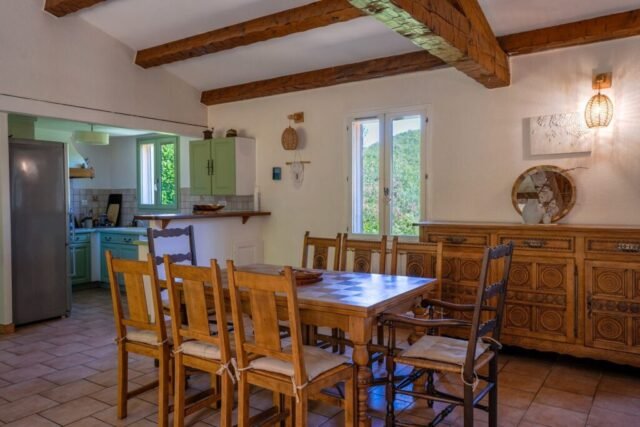 Salle à manger ouverte sur la cuisine, avec buffet ancien et accès à la terrasse Salle à manger ouverte sur la cuisine, avec buffet ancien et accès à la terrasse