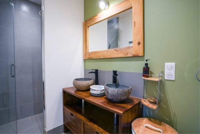 Salle de bains avec douche à l'italienne, double vasque en pierre et meuble en bois massif Salle de bains avec douche à l'italienne, double vasque en pierre et meuble en bois massif
